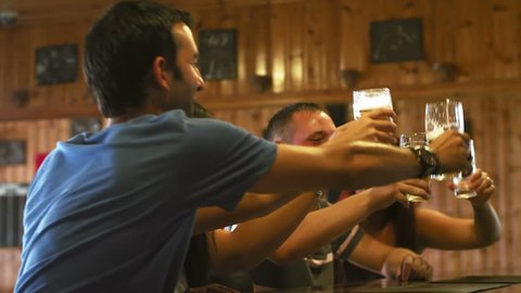 A group of friends drink beer at a bar