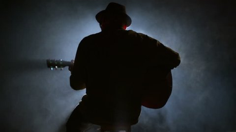 A silhouette of a guitar player sitting on a stool Stock Video