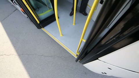 Driver closing the bus doors during the day from inside