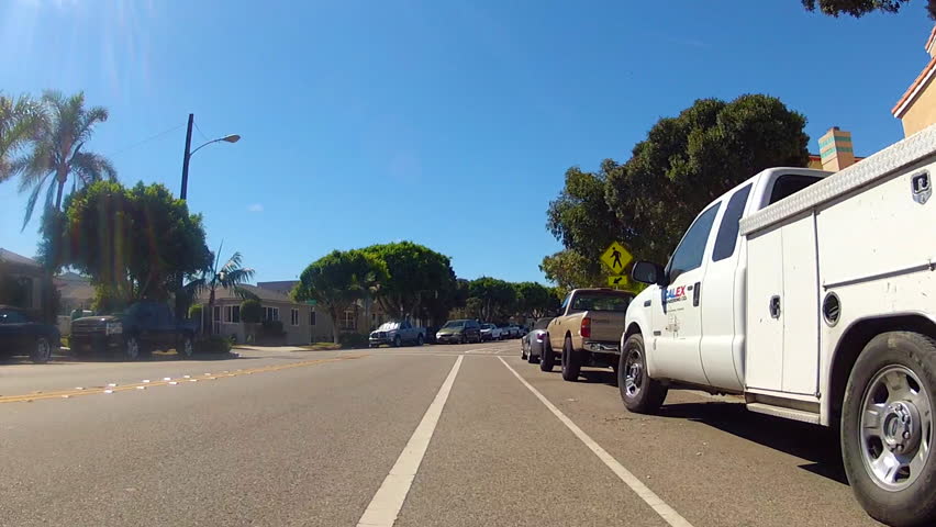The point of view of someone riding a bicycle in the bike lane of a residential