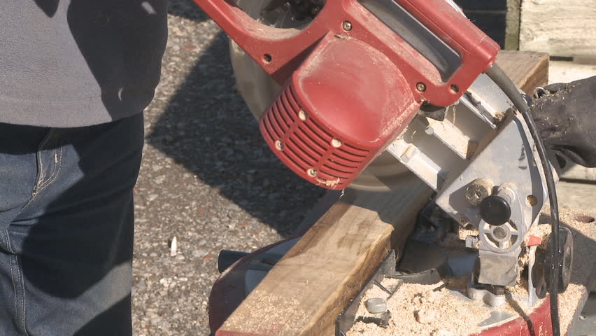Using a power saw to cut timber on a building site