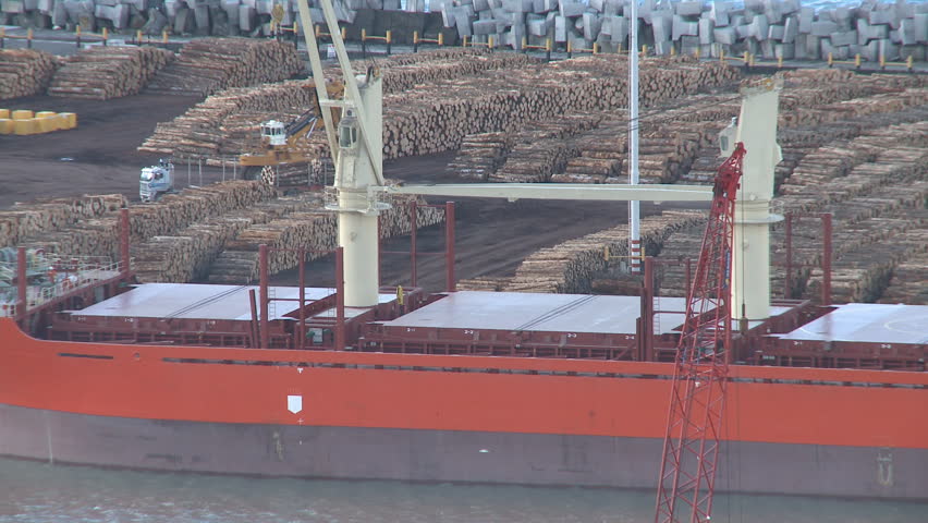 a log ship waiting to be loaded at a lumber export Port