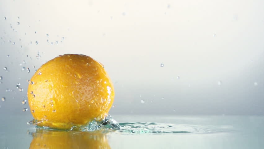 Orange splashing into water, slow motion