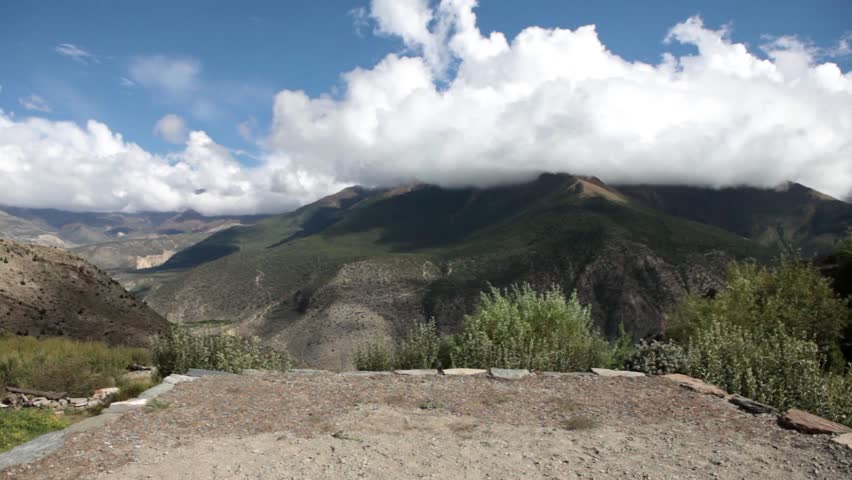 A young traveler enjoying the view atop a mountain.