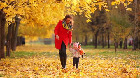 Mother and baby playing in a beautiful autumn park