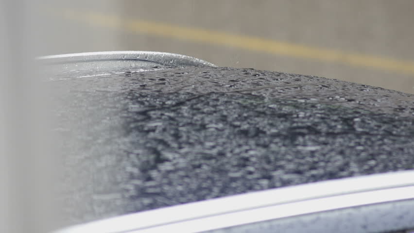 Slow Motion Close-Up Shot Of Raindrops Dripping On The Car Roof On A Rainy Day.