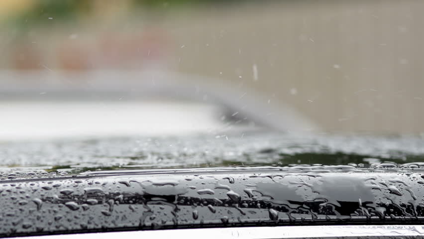 Slow Motion Of Heavy Rain Drops Splashing Onto The Car Roof On A Rainy Day.