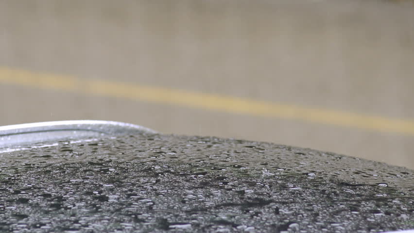 Close-Up Slow Motion Shot Of Rain Drops Falling On The Car Roof On A Rainy Day