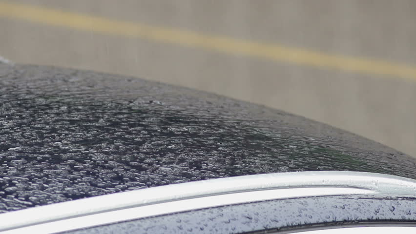 Slow Motion Of Raindrops Dripping Down The Car Roof On A Rainy Day.