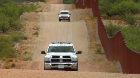 ARIZONA, USA-CIRCA 2012-Border patrol vehicles move along the U.S. Mexico border.