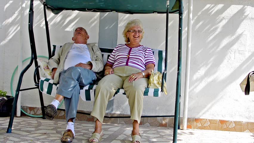 Senior couple sitting together talking, resting and having daily tea, coffee-