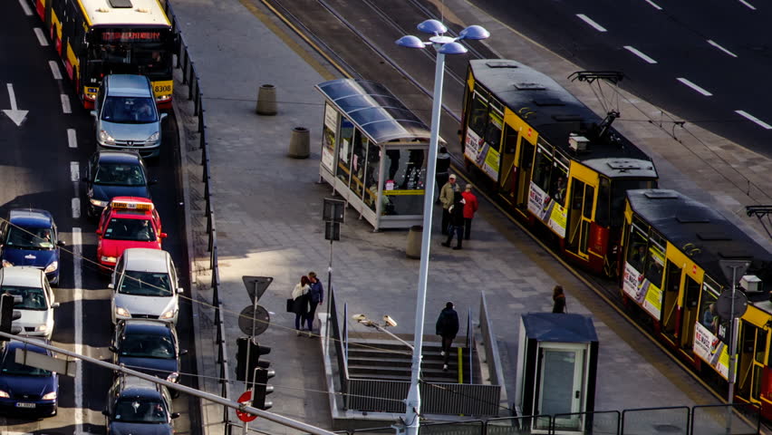 Many people walking out of a tram and into the underground in a busy city centre of Warsaw, Poland, next to a busy street, time lapse taken on the 1st October 2013