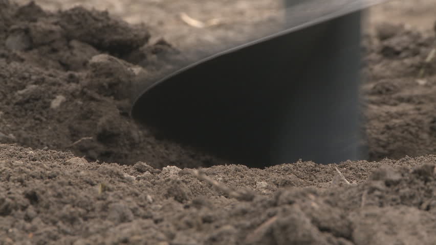 A very close view of an auger digging a hole for a post