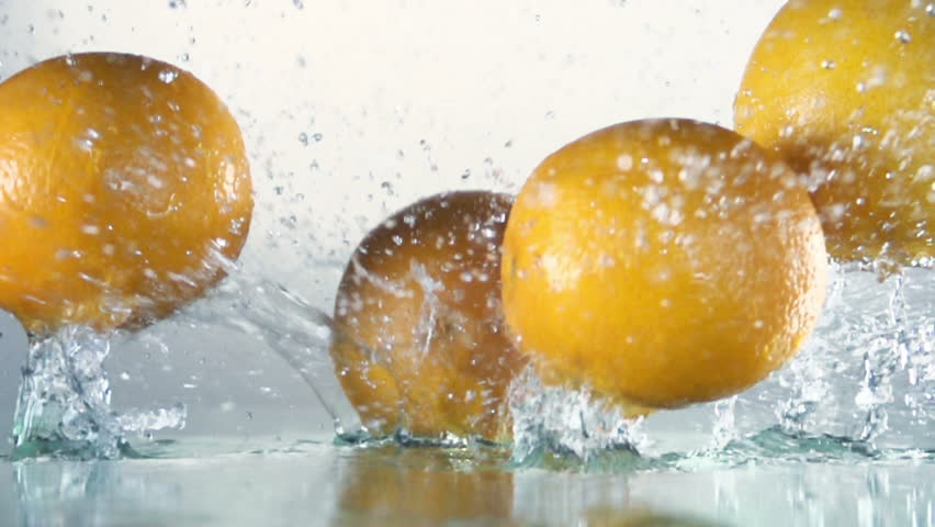 Orange splashing into water, slow motion