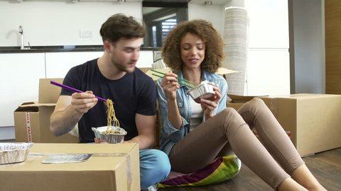 Couple celebrating moving into new home with takeaway chinese meal