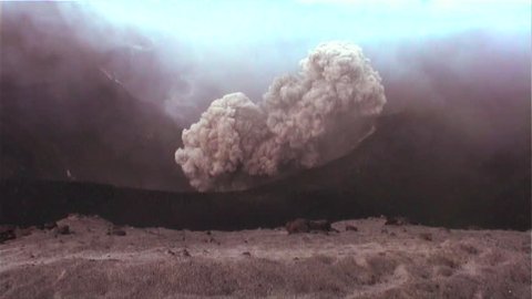 Handheld shot of a volcano erupting.