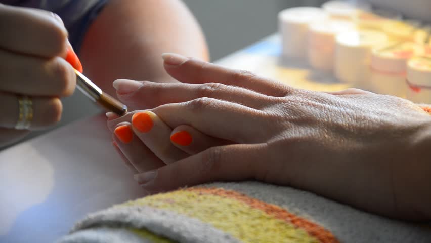 Manicure making applying nail polish. Nice manicured woman palms 