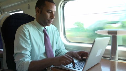 Close view of businessman working on laptop while going on business trip by train
