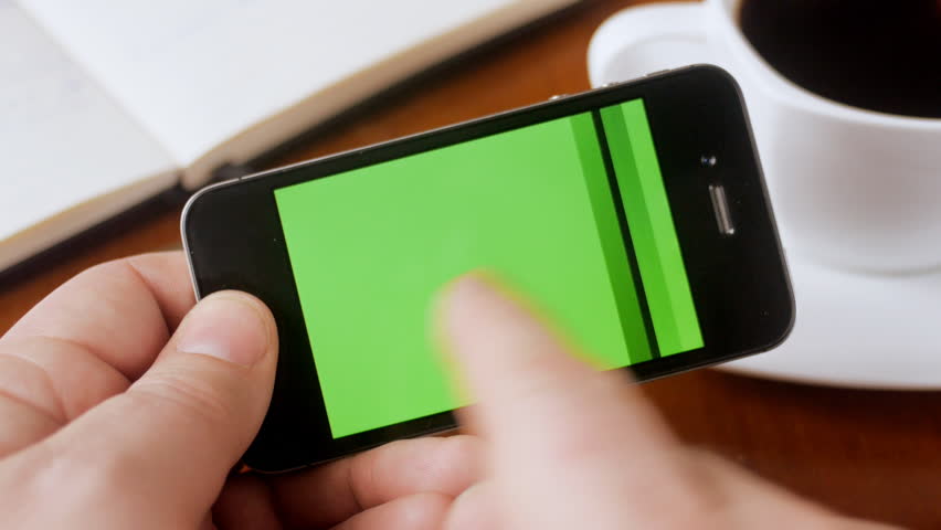 Man looking through green screen pages on smartphone