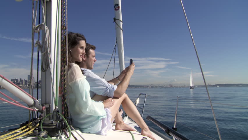 Young couple take pictures of themselves while sailing on the Puget Sound in