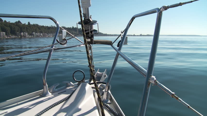 Looking over the prow of a sailing boat as it travels across Puget Sound in