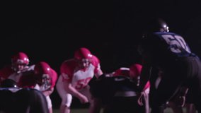 Slow motion shot of a football player receiving a ball toss and runs around the defense to gain some yards