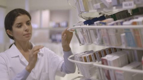 MS Female pharmacist searching medicine in pharmacy