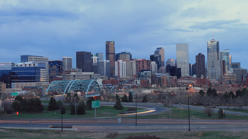 Denver skyline at dusk, with fast moving traffic on the interstate. Ultra HD 4k 