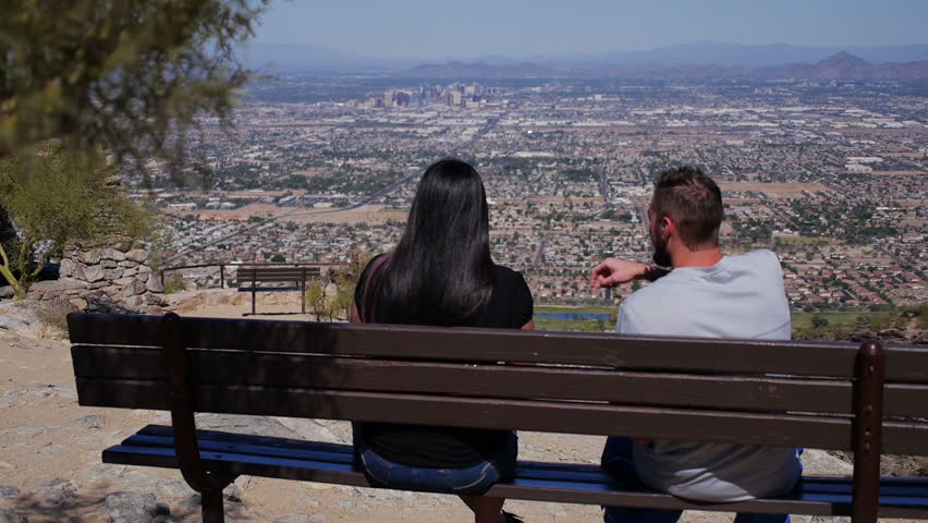 A young couple looks over Phoenix from atop of South Mountain.