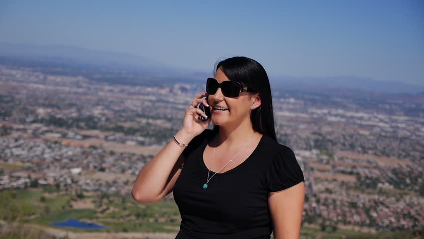 A young woman talks on her mobile phone overlooking Phoenix.