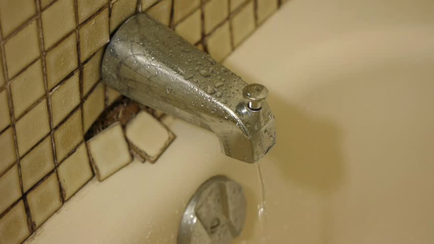 Water drips from a old and dirty bathroom faucet. It should be repair by a