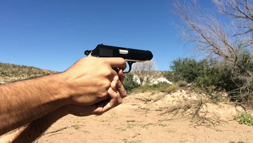 A man shoots a pistol in the desert.  Shot in super slow motion 120fps.
