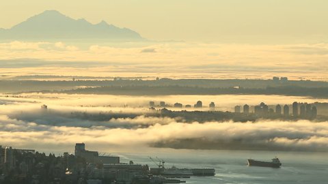 Mount Baker, Burrard Inlet Morning Fog. A high angle view of downtown Vancouver, and Burrard Inlet at sunrise. Mount Baker, in Washington State, rises through the mist. British Columbia, Canada.