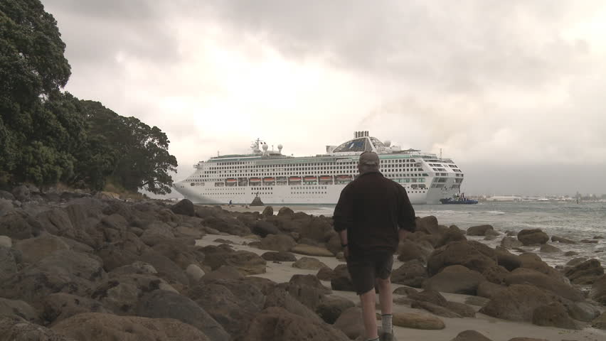 Man watches a cruise ship as it enters Port