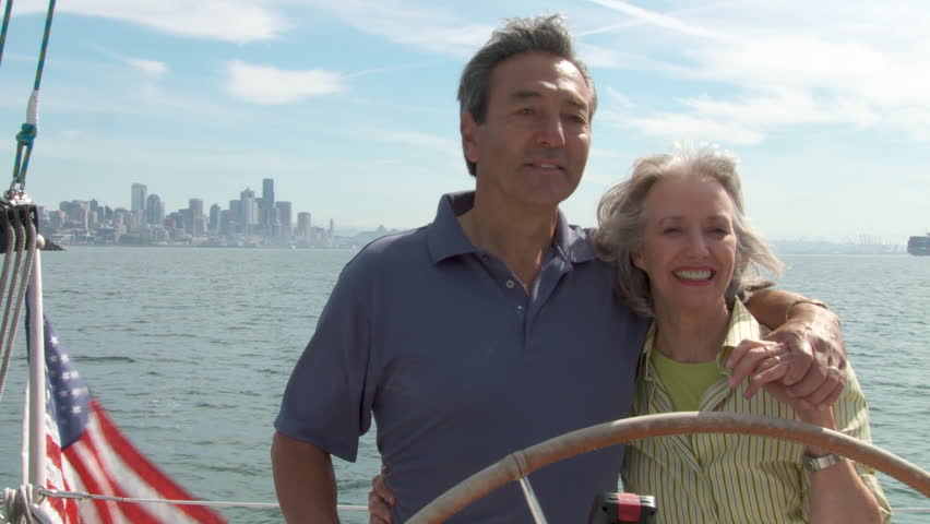 Mature couple at the helm of a yacht on the Puget Sound in Seattle, Washington. 