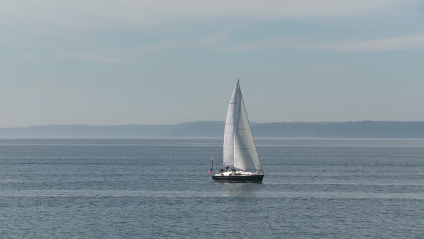 Yacht sailing on the Puget Sound in Seattle, Washington with distant mountains