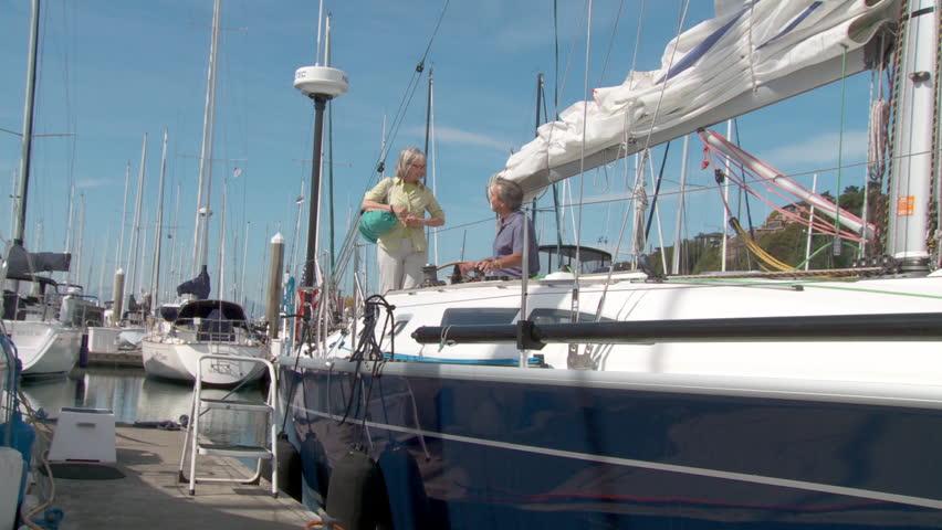 Mature couple disembarks from yacht after sailing on the Puget Sound in Seattle,