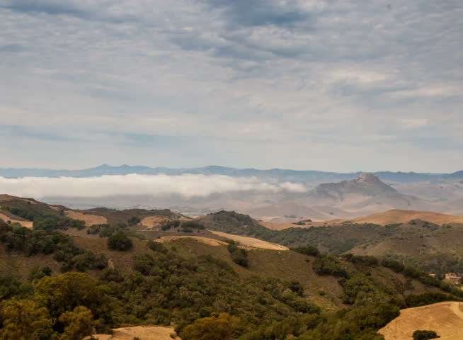 PAL - Time lapse storm clouds billow over hills and meadows.