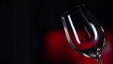 Red Wine Pouring into Glass. Black Background. Slow Motion Shot 240 fps