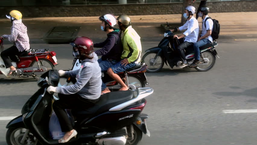 HO CHI MINH CITY - 7 OCTOBER: Panning view of people on motorbikes in Ho Chi