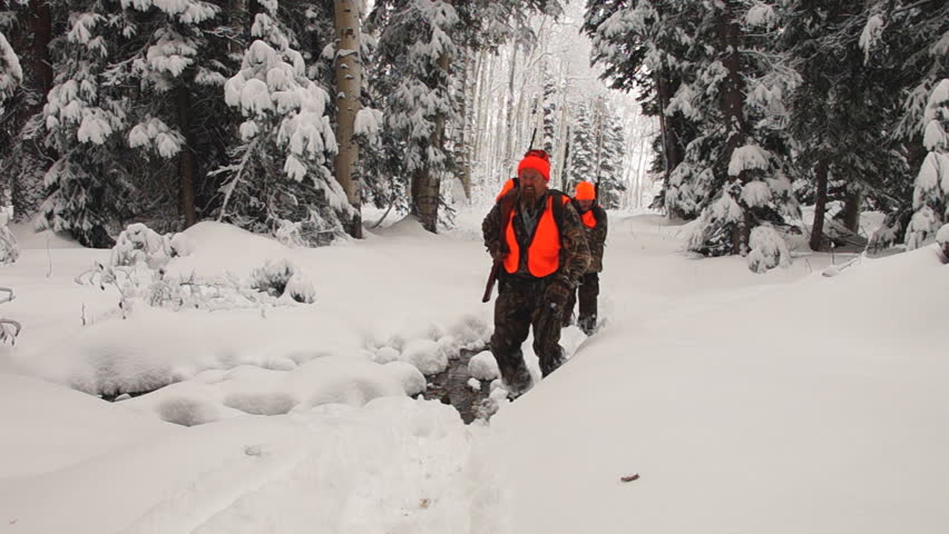 Elk hunters hiking through deep snow in northern Colorado wilderness after an