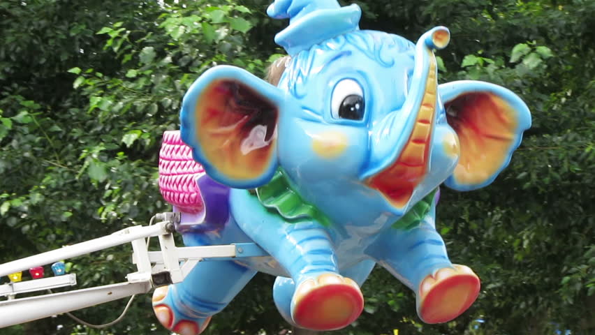 little girl riding on elephants carousel