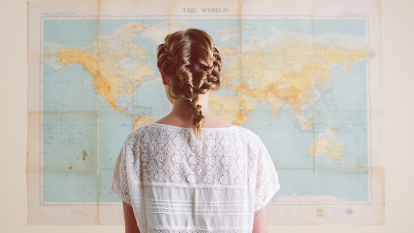femme qui regarde une carte du monde