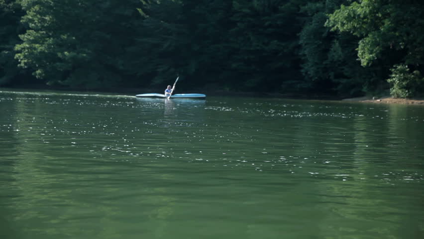 Man kayaking on lake in competition