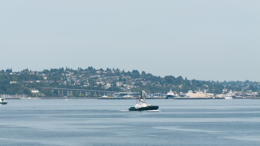 Ferry and a tug boat sail across the Puget Sound in Washington state towards the