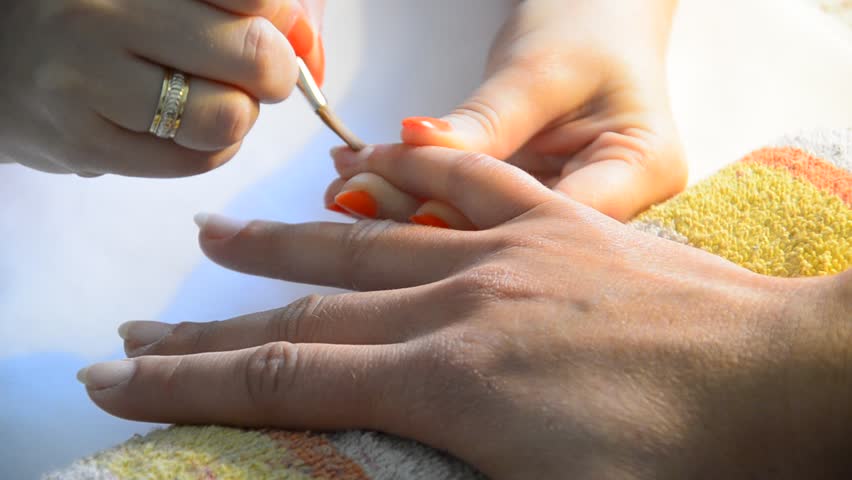 Manicure making, nile polishing and protection applying. Nice manicured woman