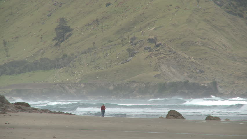 A lone walker along a deserted and wild beach