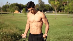 muscular young man doing arm exercises with a resistance band