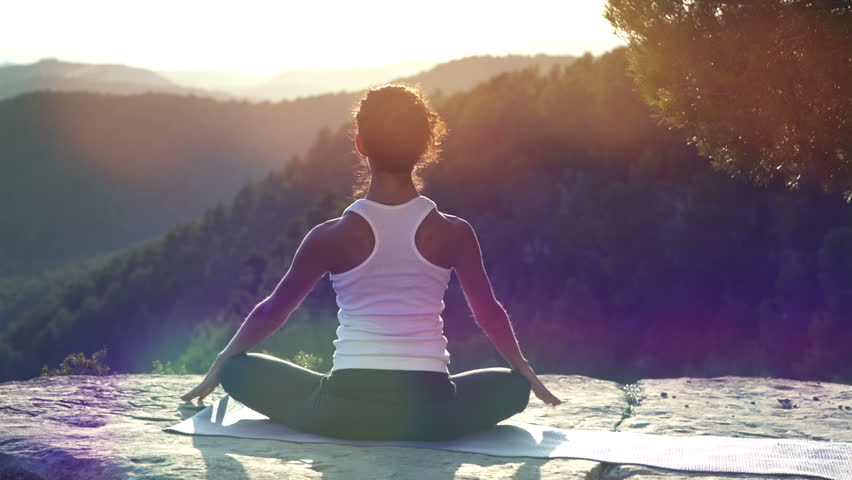 Beautiful young woman practices yoga moves and positions outdoors on an incredible clifftop setting
 | Shutterstock HD Video #4920815
