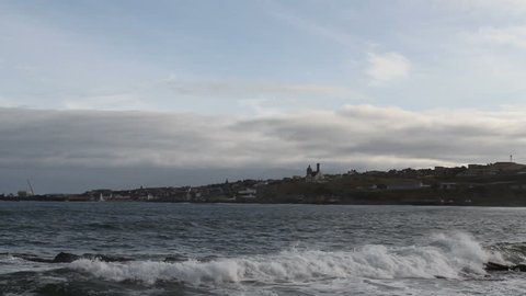 Crashing waves and Macduff waterfront Scotland